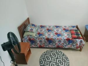 苏瓦Barrett Accommodation Budget Rooms的一间卧室配有一张床和一张带风扇的桌子。