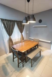 巴生Akmal Homestay Klang的一间带木桌和椅子的用餐室