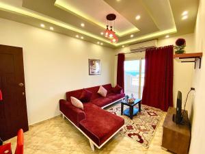 赫尔格达Charbel apartments的客厅配有红色沙发和电视
