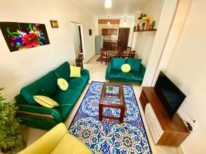 赫尔格达Charbel apartments的客厅配有绿色沙发和桌子
