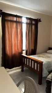 拉塞瓦Vacation Home La Ceiba的一间卧室配有床和带窗帘的窗户