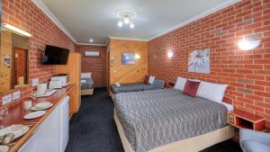 蒂默特榆树汽车旅馆的小房间,设有床和砖墙
