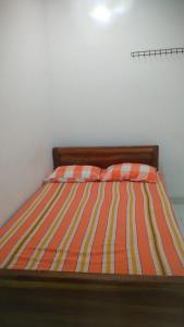 亭可马里JM resort的一张带橙色和黄色条纹棉被的床
