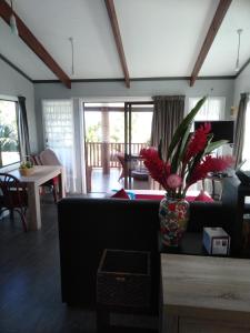 阿罗朗吉Te Moana Nui Villas的客厅配有沙发和鲜花花瓶