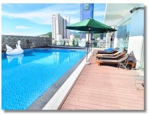 归仁FLC Quy Nhon Beach Apt的一座大楼内的游泳池,配有遮阳伞和天鹅