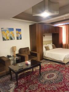 安曼阿哈蒂尔酒店的一间卧室配有一张床、一张沙发和一张桌子