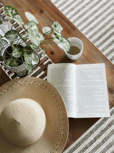 马莱尼"On Burgum Pond" Cottages的一张桌子,上面有一本书,一顶帽子和一盘