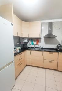 马德里安静双人房的厨房配有木制橱柜和白色瓷砖地板。
