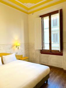 佛罗伦萨杜卡德奥斯塔酒店的卧室设有一张白色大床和一扇窗户。