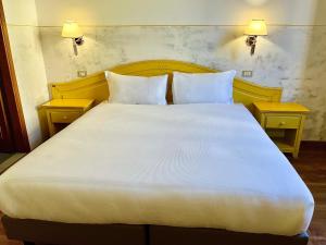 佛罗伦萨杜卡德奥斯塔酒店的一张大白色的床,位于带两张桌子的房间