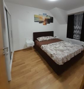 索科矿泉村KONAK ViLA MIRKOVIĆ的一间卧室配有一张床,铺有木地板
