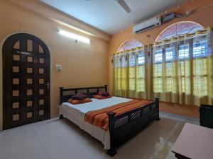 古瓦哈提Saikia Nest the Home-stay的一间卧室设有一张床和两个窗户。