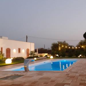 孔韦尔萨诺CASA VACANZA DONNA LINA的夜间在房子前面的游泳池