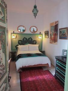突尼斯天井庭院旅馆的一间卧室配有一张大床和红色地毯。