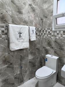 拜尔卡Bareeq Rest House的浴室配有卫生间和墙上的毛巾。