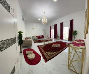 拜尔卡Bareeq Rest House的客厅拥有白色的墙壁和红色的地毯