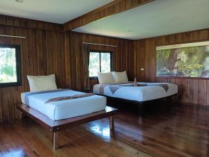 俊穆岛Kohjum Freedom Resort的木墙客房的两张床