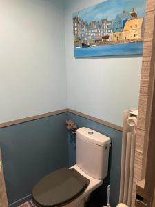 列万Le cèdre bleu的浴室设有卫生间,墙上挂有绘画作品
