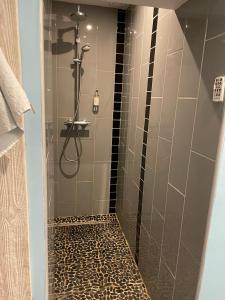 列万Le cèdre bleu的浴室设有淋浴和豹式瓷砖地板。