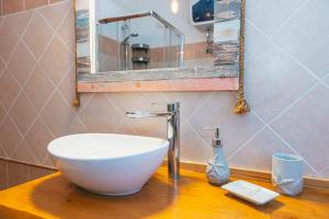 皮诺港Case Vacanze Il Sogno的木制柜台上带白色碗水槽的浴室