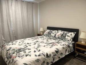 奥克兰Murphys Guest Home的一间卧室配有一张带被子和枕头的床