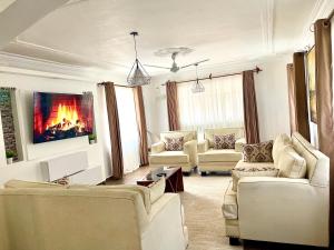 蒙巴萨Mudzini gardens - Luxury villa with a pool的客厅配有白色家具和壁炉