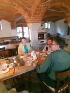 班斯卡比斯特里察Tubej turist farm - wooden hayloft的一群坐在餐桌旁吃饭的人