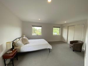 桑迪角Sandy Point Beach Escape 2 Bedroom Apartment的白色卧室配有床和椅子