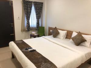 班加罗尔Hotel Amulya Regency的卧室设有一张白色大床和一扇窗户。