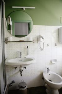 玛里纳罗米亚Hotel Millepini的一间带水槽、镜子和卫生间的浴室