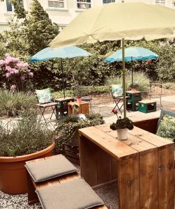 威廉港beans parc hotel jade的一个带桌椅和遮阳伞的庭院