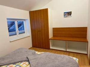 上特劳恩Haus Edelweiss的一间卧室配有一张床和一个木制橱柜