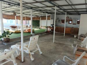 南芭堤雅Chuencheewa Resort的一间设有白色椅子和绿桌的房间