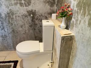 本托塔River Shadow Villa的浴室设有卫生间,在柜台上摆放着鲜花。