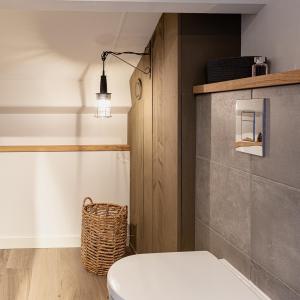 宁斯佩特Huusje21的浴室配有卫生间和墙上的灯。