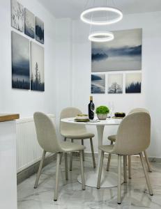 LupeniMarbleHome~Straja/Lupeni的一间配备有白色桌椅的用餐室