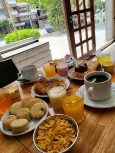 马德普拉塔Hotel Bertiami的餐桌上摆放着早餐食品和饮料