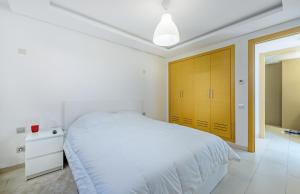 卡萨布兰卡Urban Charm Delight的白色卧室设有一张大床和黄色的门