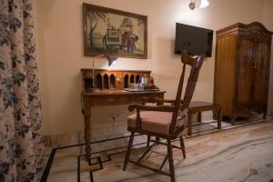 比卡内尔Cavalry Villa bikaner的客房设有一张桌子、一把椅子和一台电视