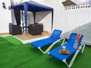 卡勒达德福斯特Casa Yanira的绿色地毯上的两把蓝色和白色椅子