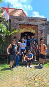 乌干沙The Jiwana Bali Resort的一群人站在一座建筑物前摆着一张照片