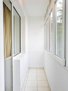 布加勒斯特Central Dream & Lounge的走廊设有窗户,铺有白色瓷砖地板