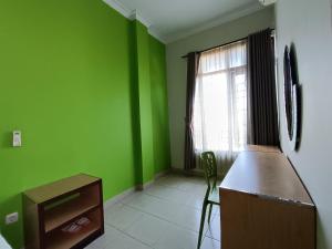 日惹The Cabin Hotel Ngupasan的绿色的客房设有柜台和窗户。