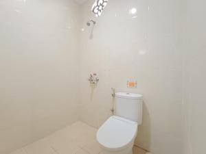 日惹The Cabin Hotel Ngupasan的白色的浴室设有卫生间和水龙头。