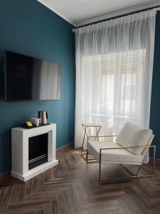 维纳利亚瑞勒Casa Del Caval Bianco的客厅配有平面电视和椅子。
