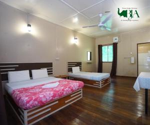京那巴当岸Borneo Jungle Adventure的一间卧室配有两张床和吊扇