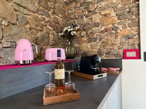 普罗旺斯地区特朗Love Room du Moulin Rose的柜台上坐着一瓶葡萄酒