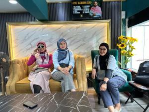 吉隆坡SS Grey Hotel的三个女人坐在商店的沙发上