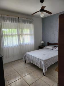 因贝Casa Andar Térreo - Balneário Nordeste - Imbé - RS的一间卧室配有一张床和吊扇