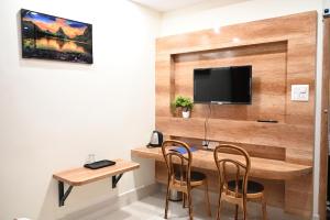 ChāsTHE M K HOTEL -Luxury In Style的客房设有一张桌子、两把椅子和一台电视。